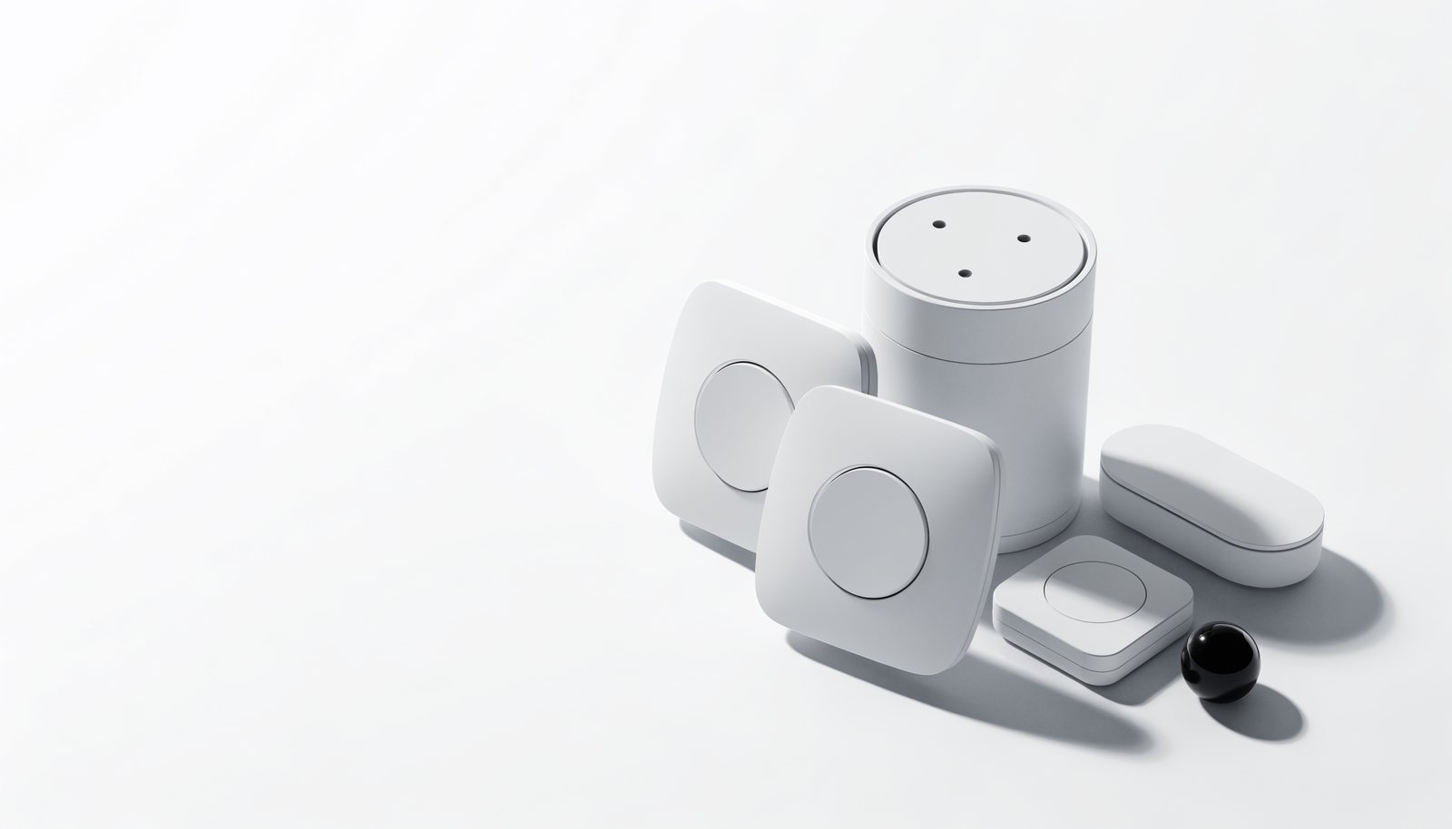 Smart-home hardware - switches, a hub and sensors - on a clean surface